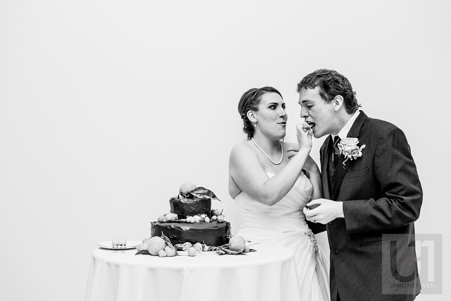 The bride feeding wedding cake to the groom during their wedding reception