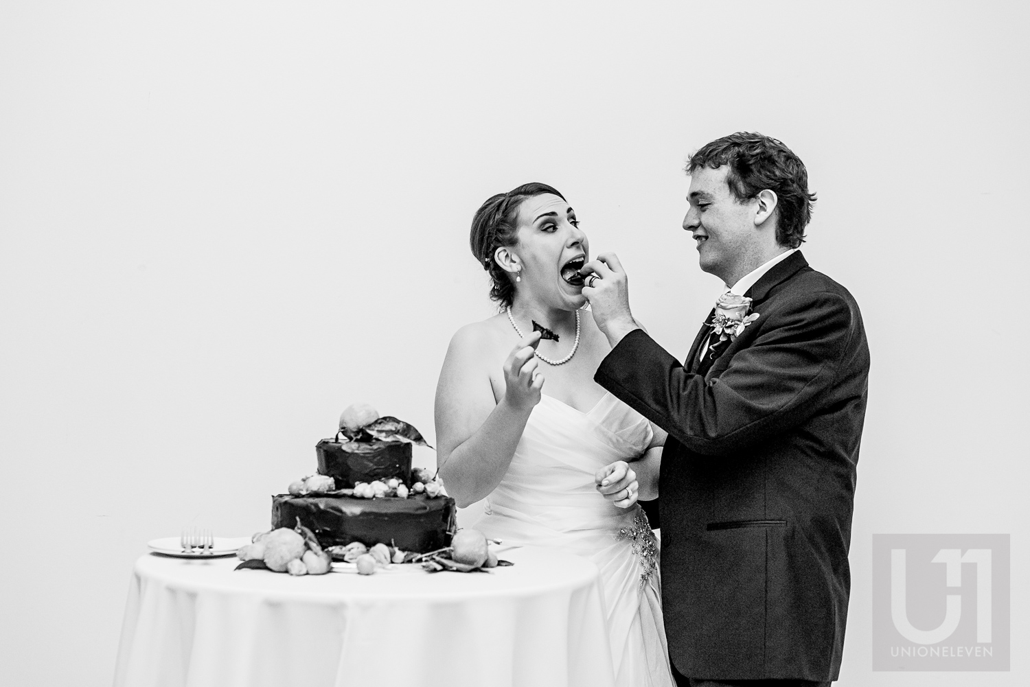 The groom feeding wedding cake to the bride at their wedding reception