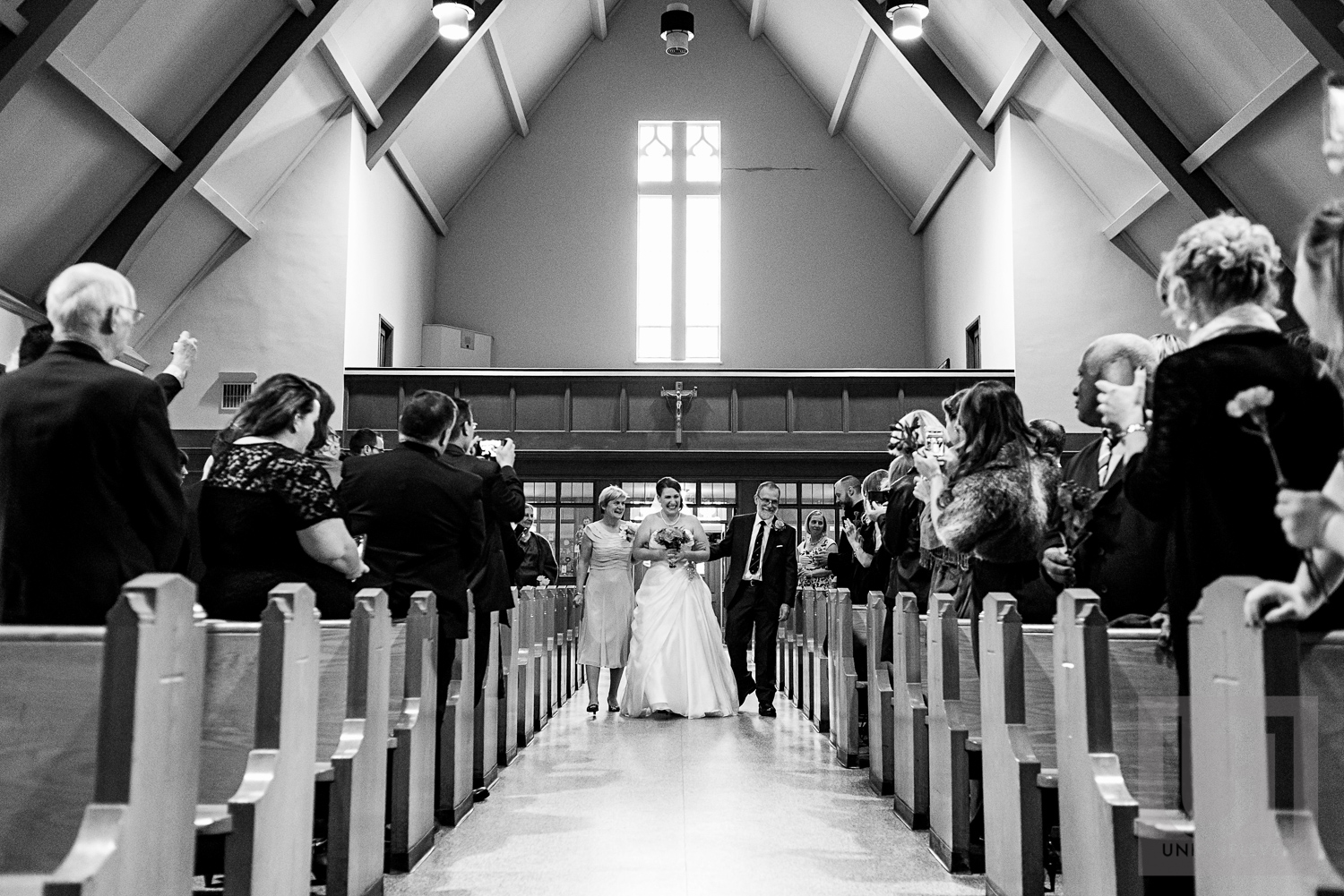 The bride being walked down the aisle by her parents