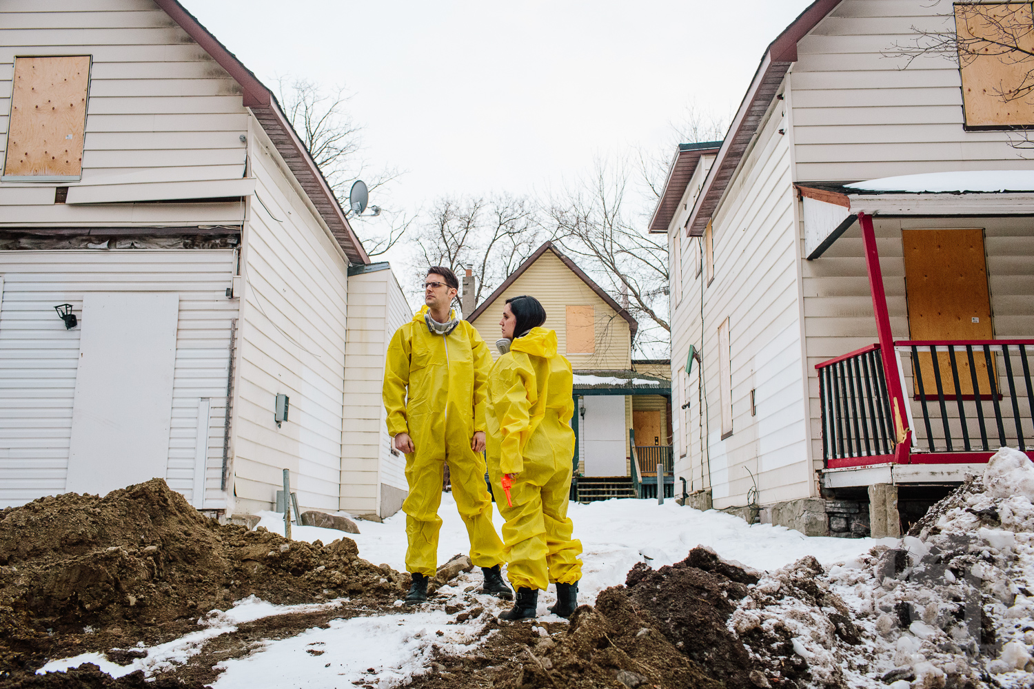 Engagement shoot of the couple doing a dramatic pose dressed in their hazmat suits