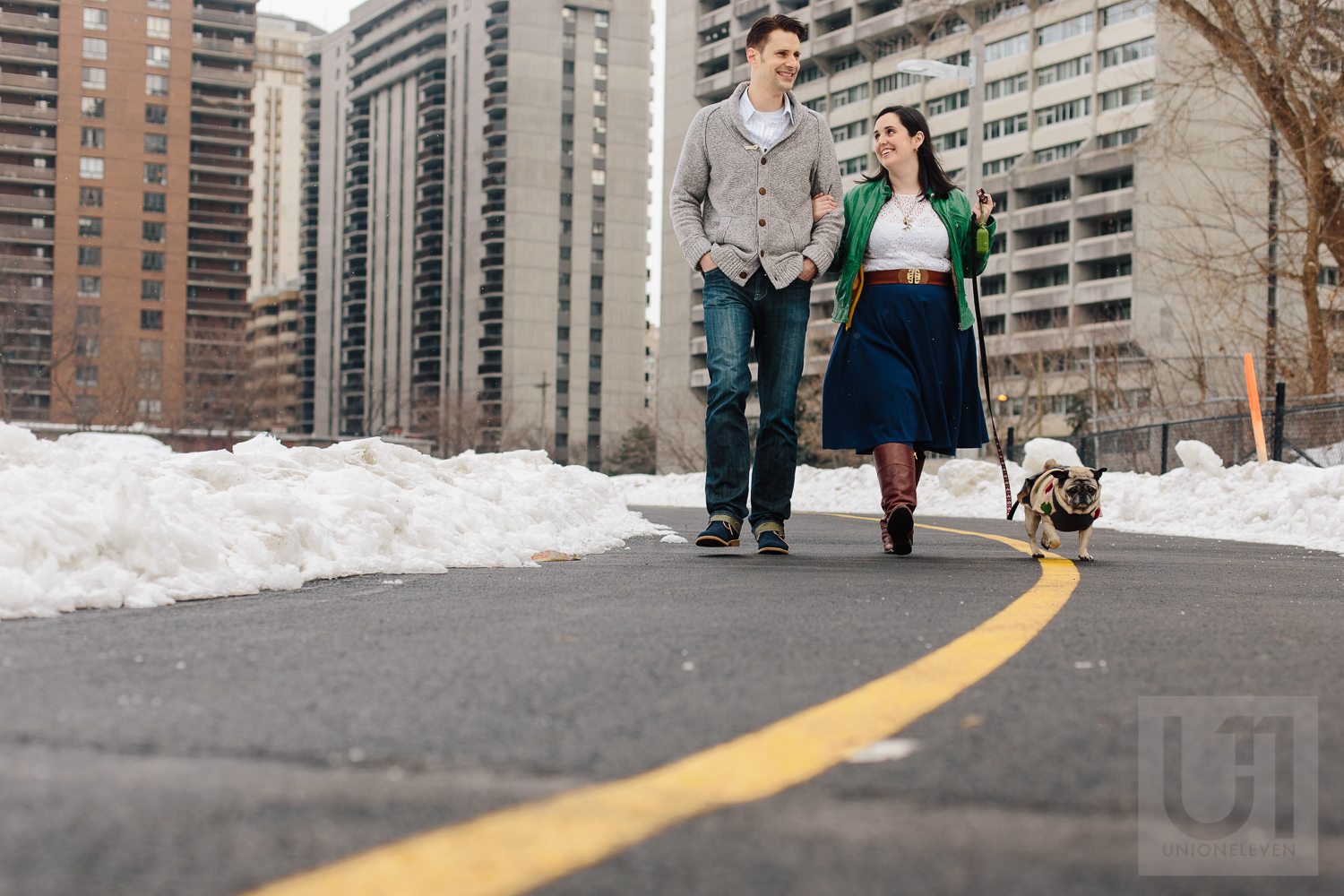 Engagement shoot of the couple and their pug going for a walk in downtown ottawa