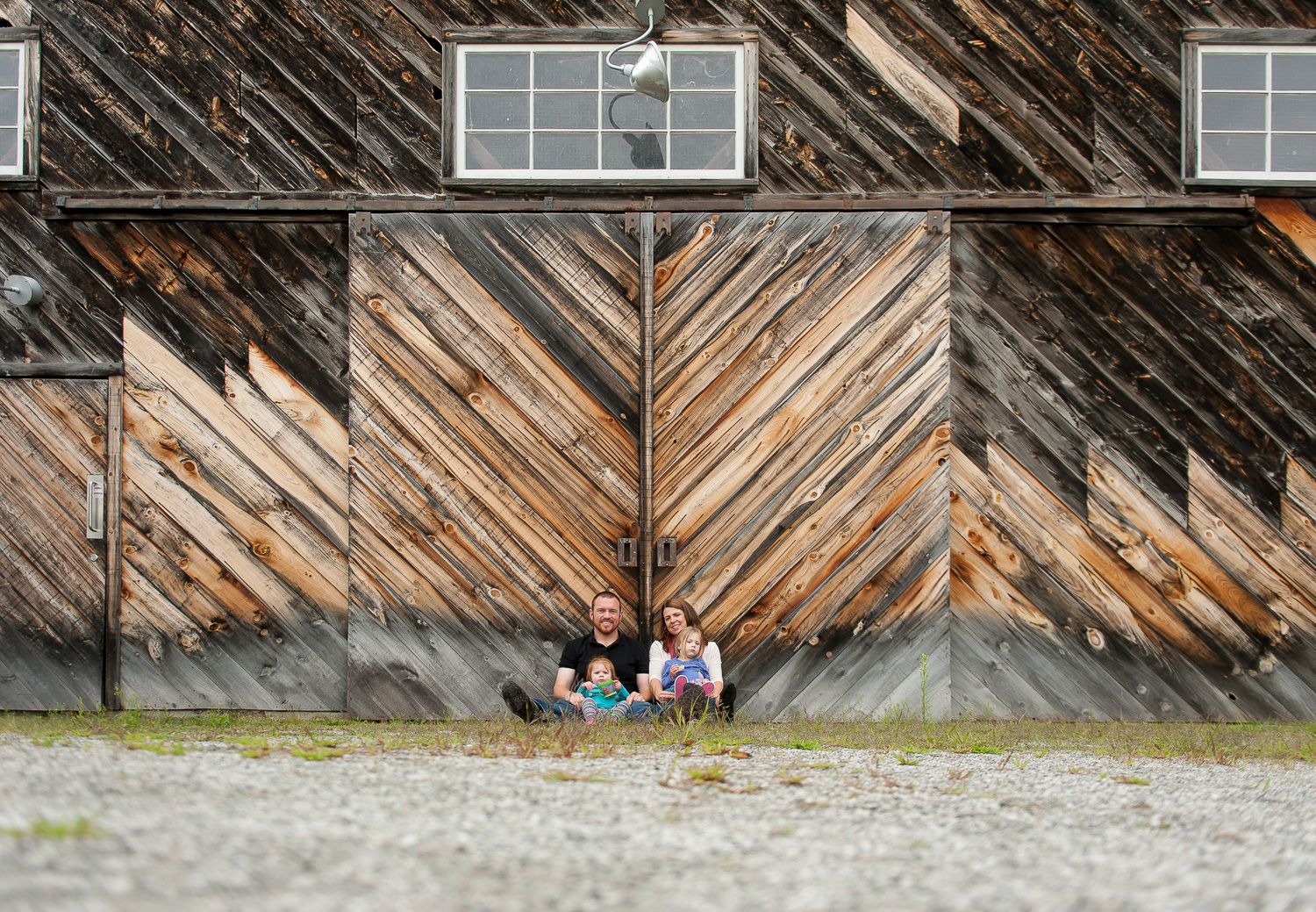 portrait of a family with a baby in front of a barn (Copy)