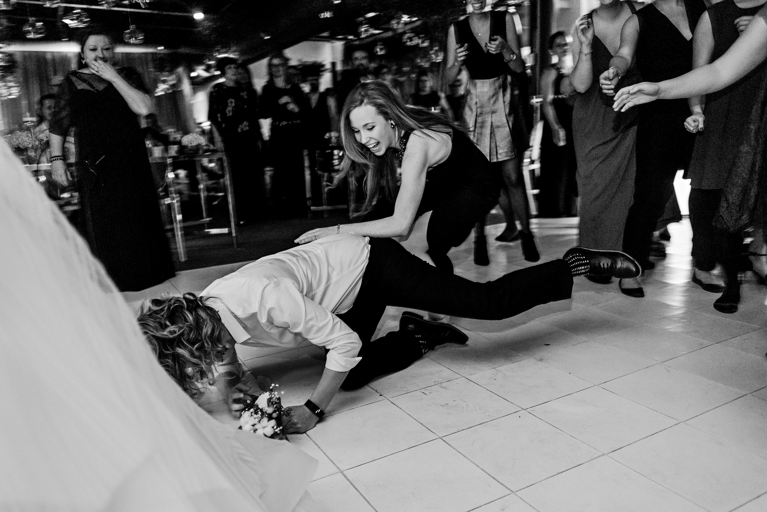 Guests diving onto the dance floor during the bouquet toss