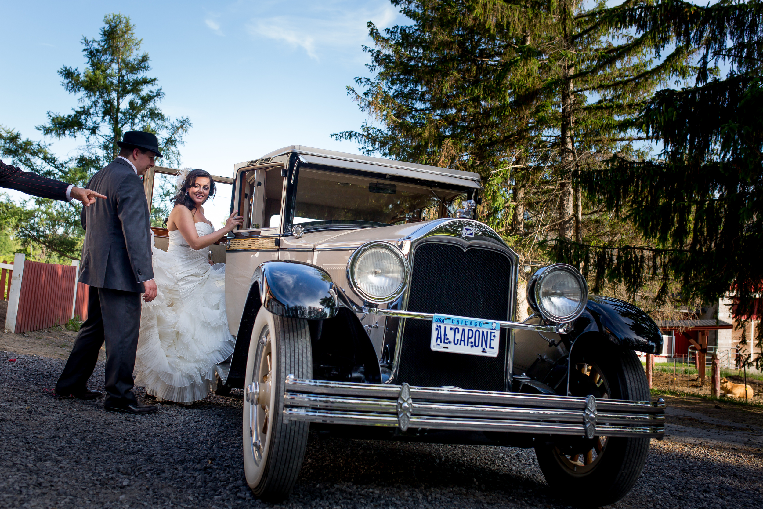 The bride and groom leaving the reception in a vintage car