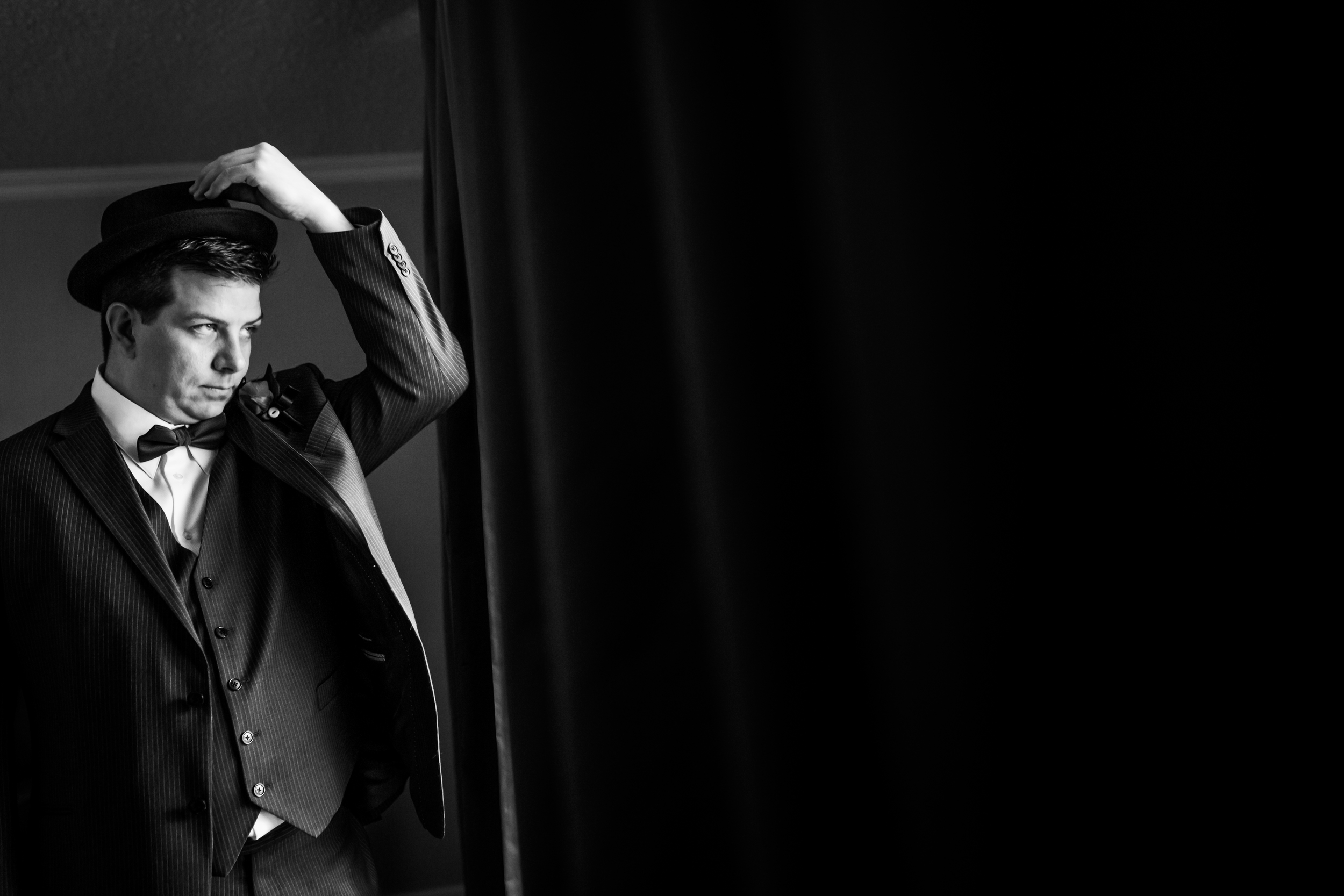 A photo of the groom in his suit and bowler hat