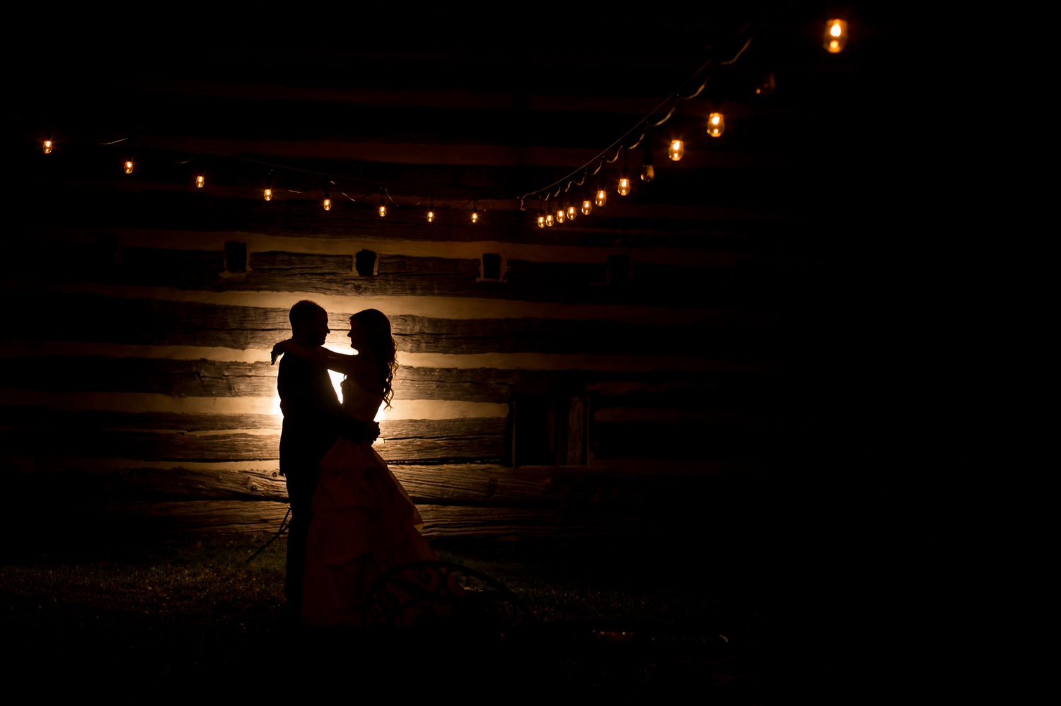 A silhouette portrait of the bride and groom outside the Stonefields barn