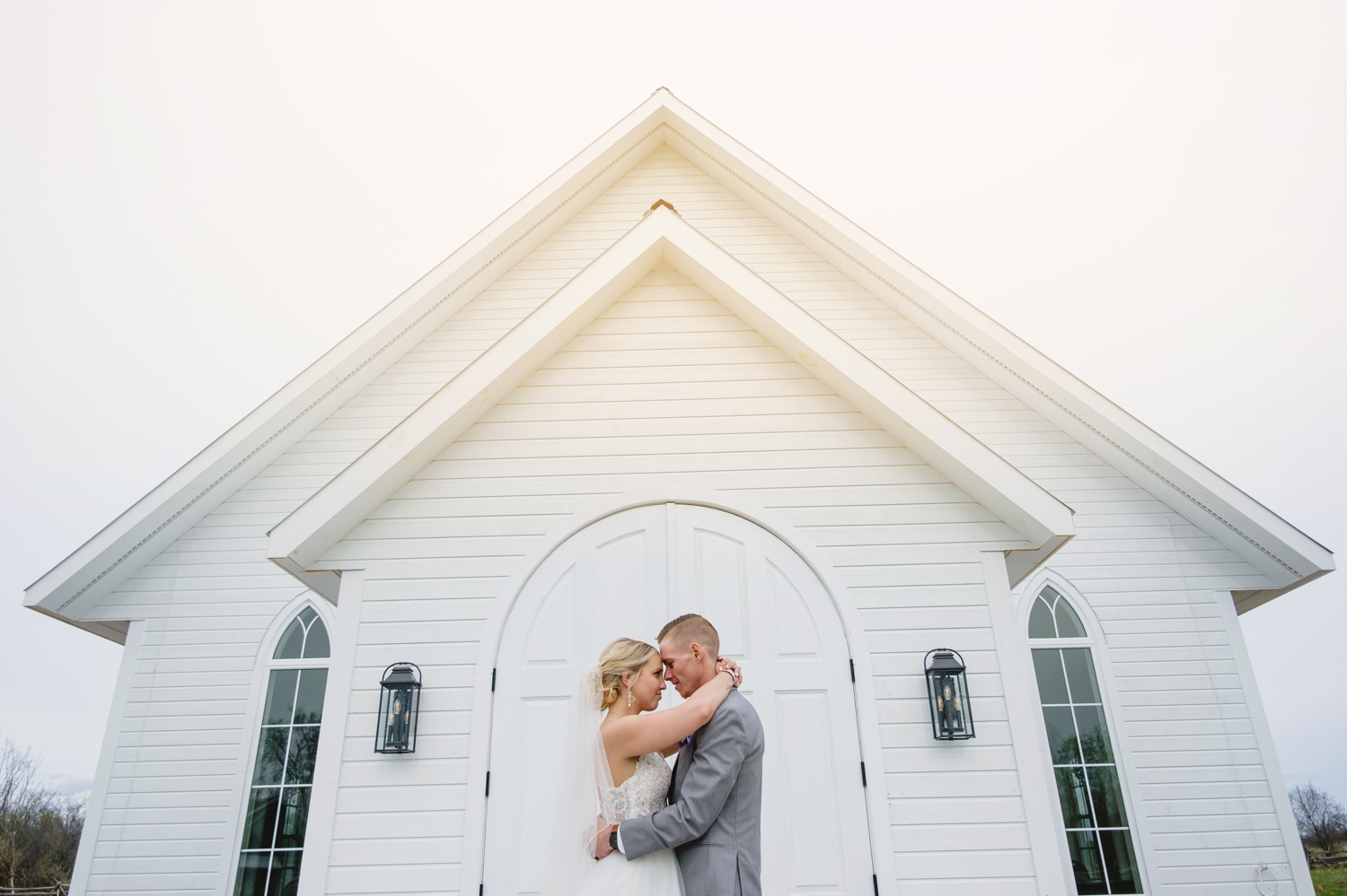 bride and groom portrait in front of the new ceremony house stonefields estate in carleton place ontario