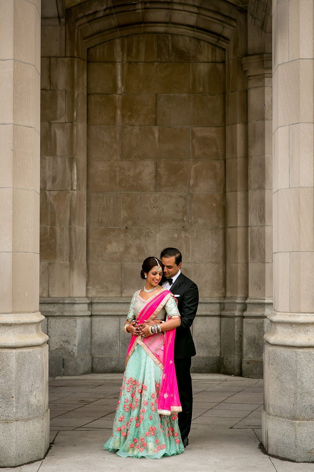 Indian couple in an embrace between columns outside Ottawa's Fairmont Chateau Laurier