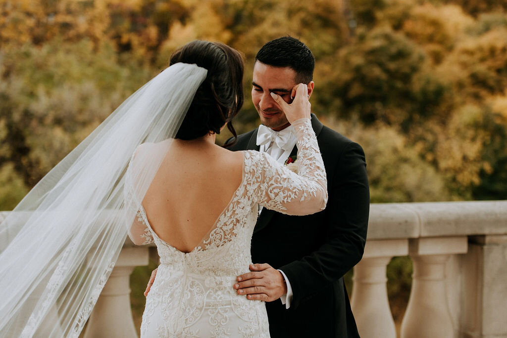 bride wiping away groom's tears during first look outside Ottawa Chateau Laurier