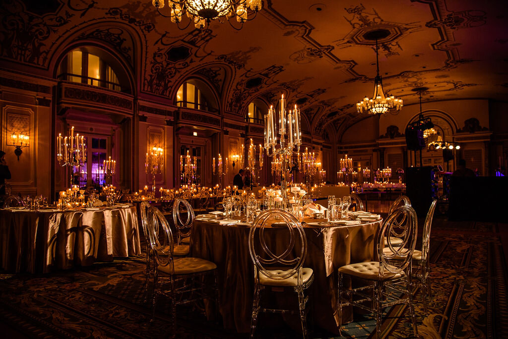 round tables with candelabras and clear oval chairs set up inside Chateau Laurier ballroom