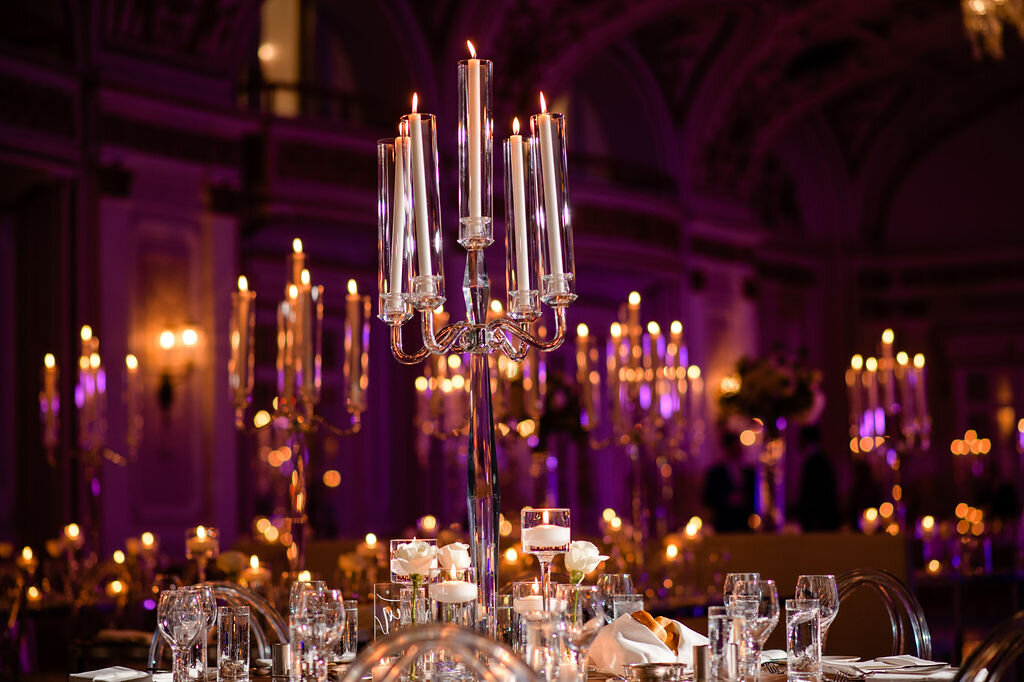 wedding reception tablescape featuring a candelabra and purple uplighting inside Chateau Laurier ballroom