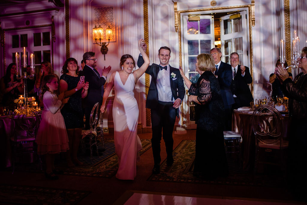 bride and groom making grand entrance in Chateau Laurier reception space as wedding guests applaud
