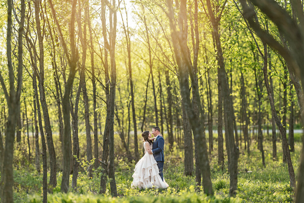 bride and groom standing in an embrace in the forest at Stonefields Estate