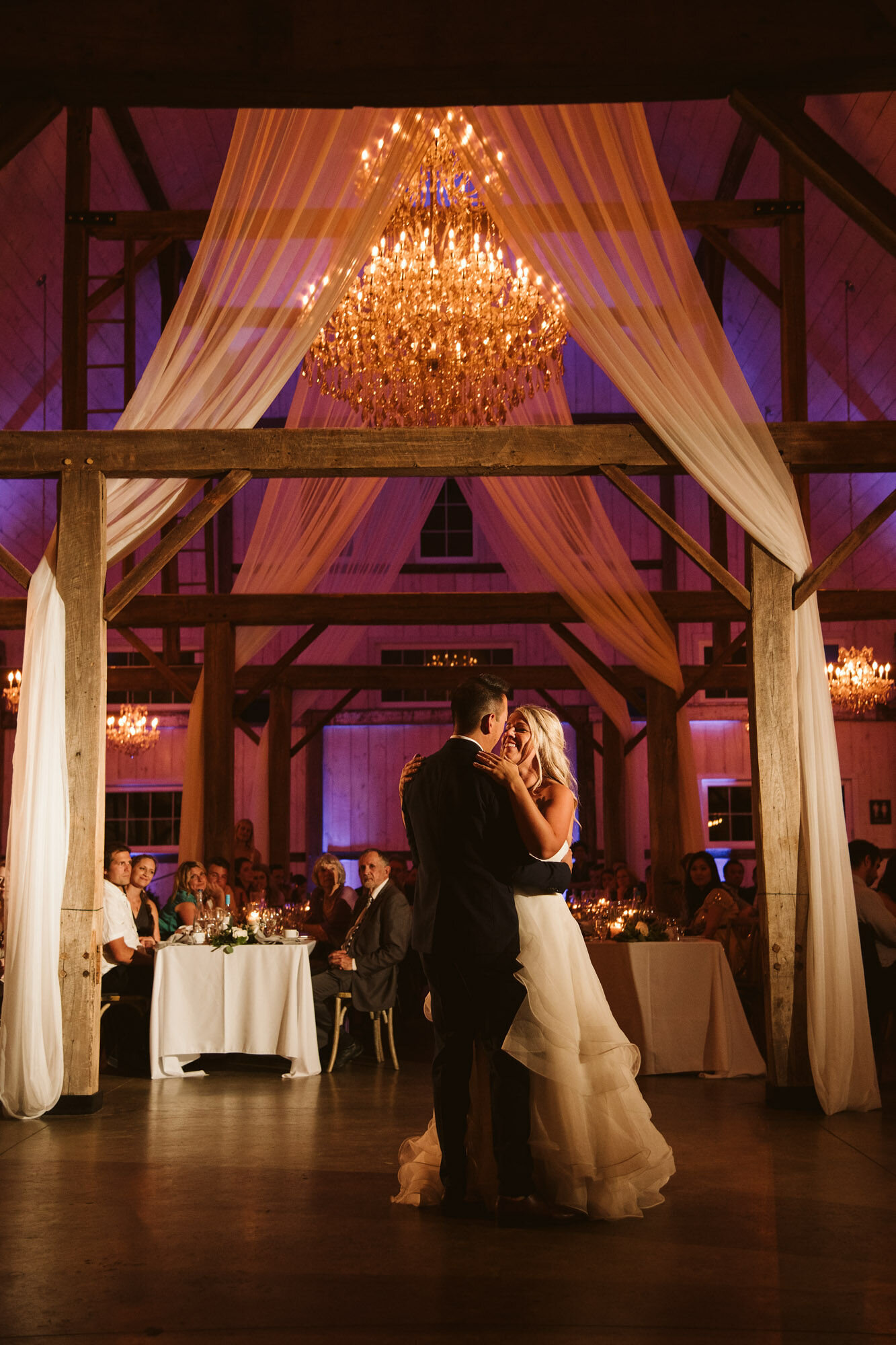 First dance between bride and groom inside decorated country barn at Stonefields Estate
