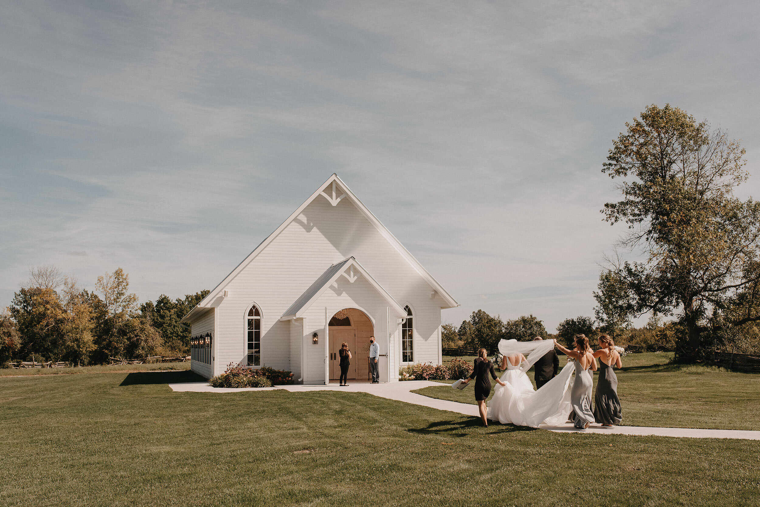 bride and bridesmaids walk into ceremony house for a wedding at stonefields estate in carleton place ontario (Copy)