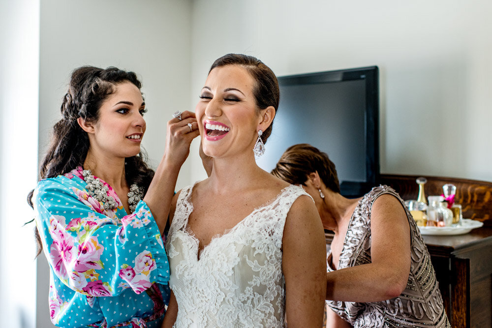 photo of bride laughing while getting ready for her wedding
