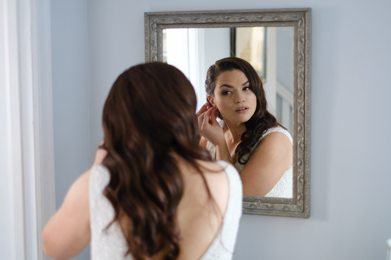 bride putting her earrings in 