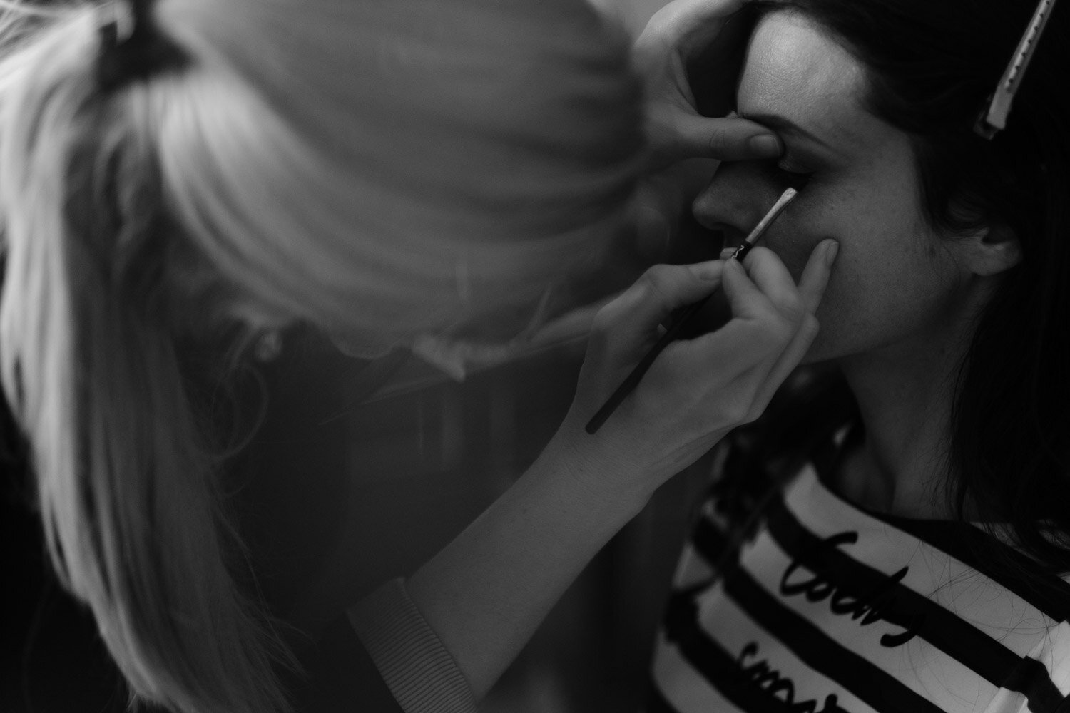 black and white photo of a bride getting her makeup done