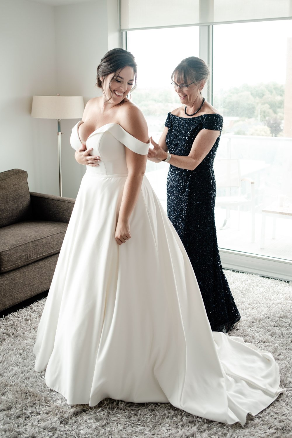 photo of a mother helping her daughter put on her wedding dress