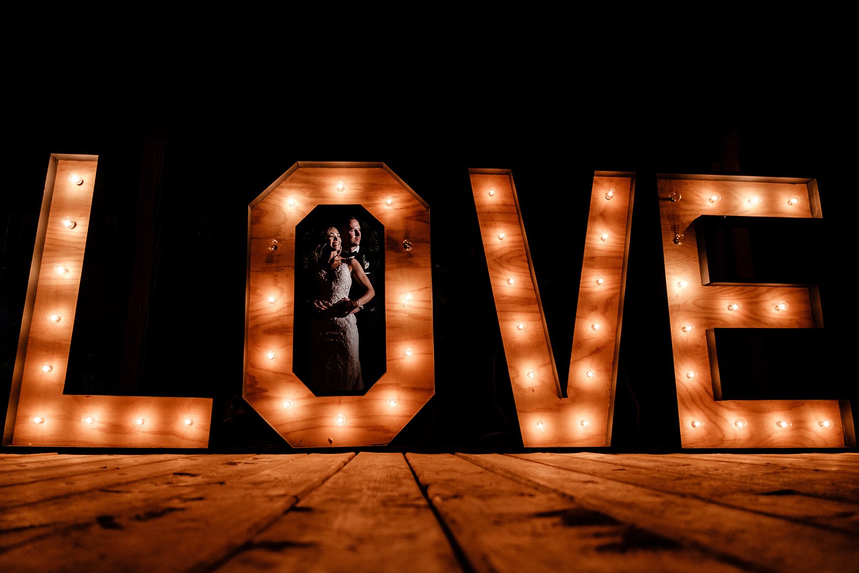 bride and groom pose with love sign at a wedding at evermore in almonte (Copy)