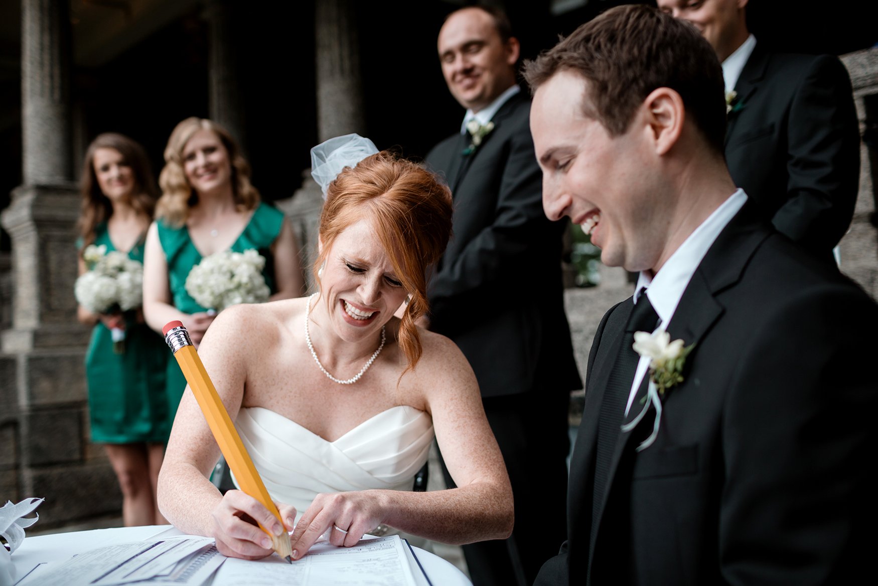 bride signs wedding license with big pencil during a ceremony at the rockcliffe park pavillion ottawa (Copy)