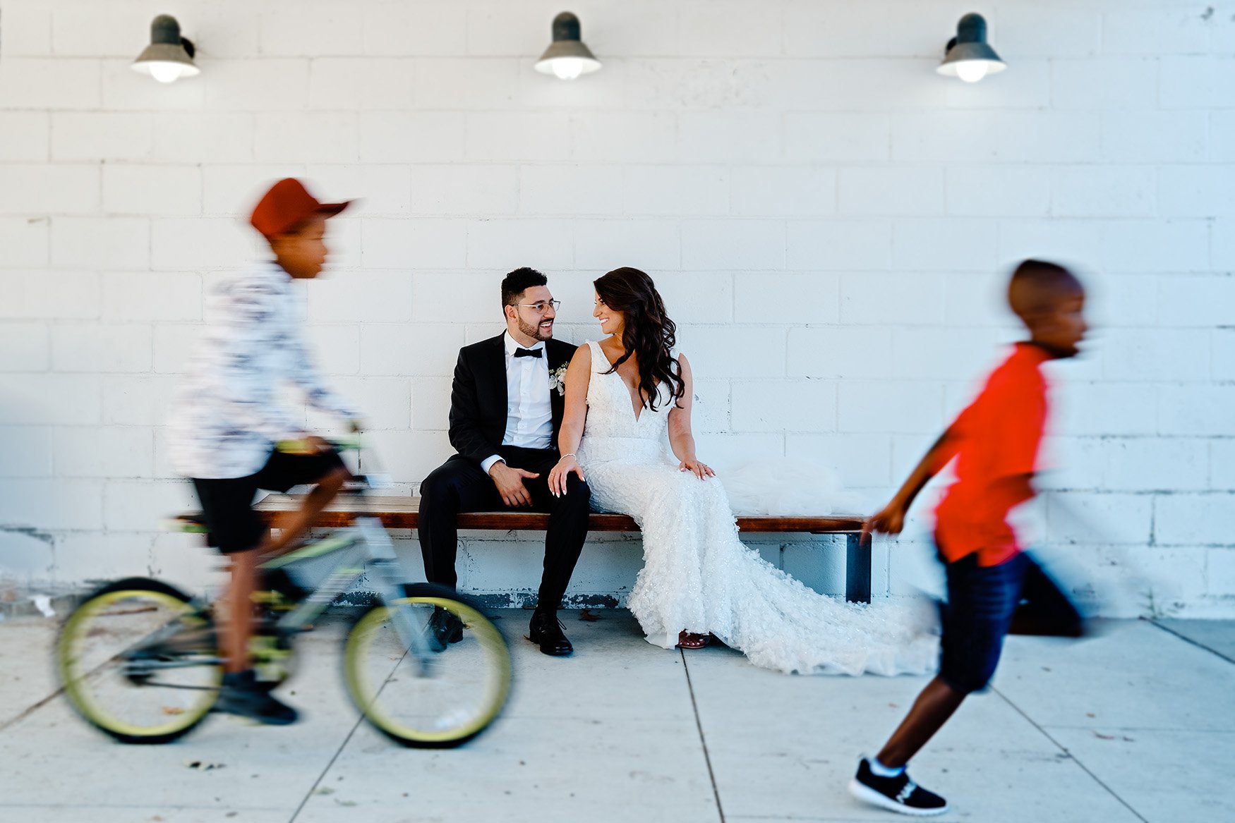 bride and groom pose for portrait while kids play (Copy)