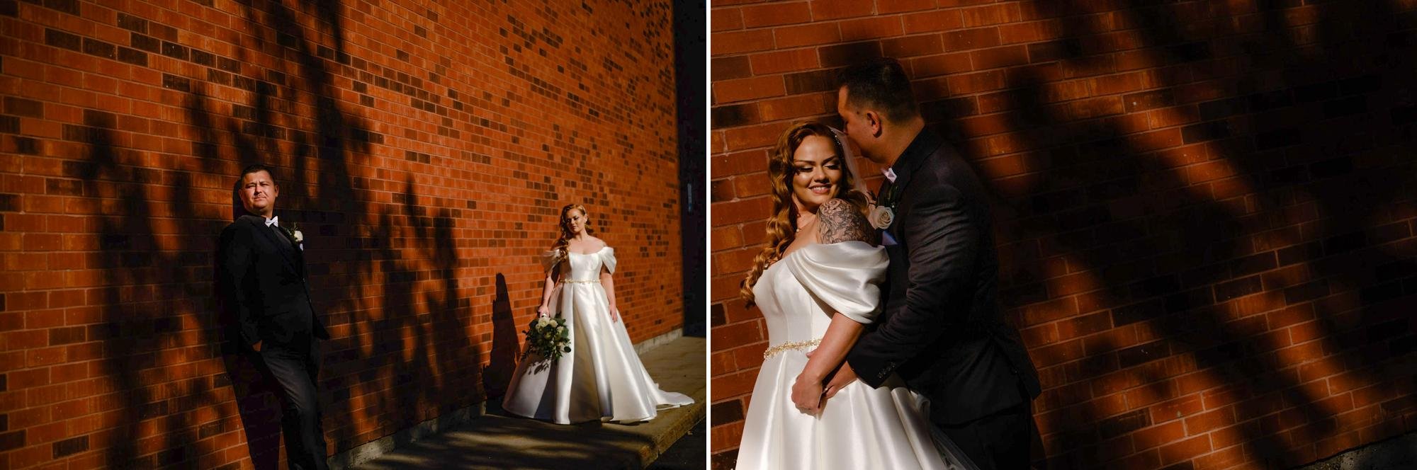 dramatic hard light wedding photo in front of a brick wall