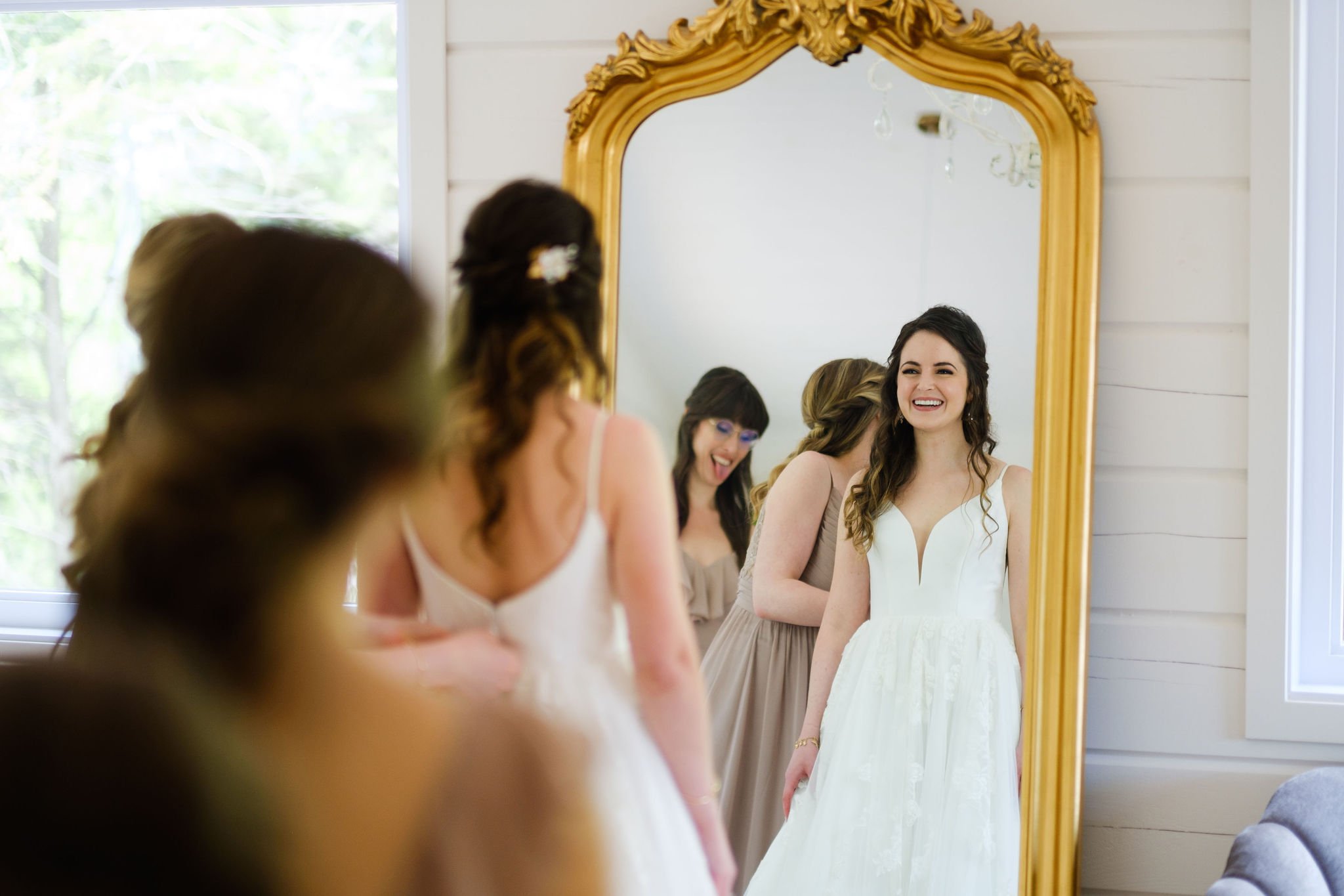  a bride seeing herself in the mirror in her wedding gown 