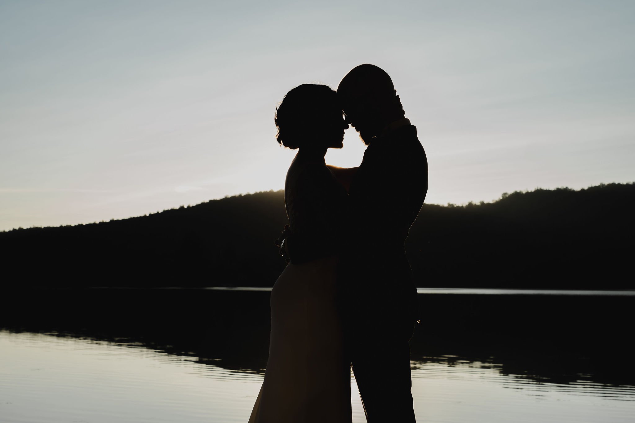 silhouette photo of a bride and groom embracing