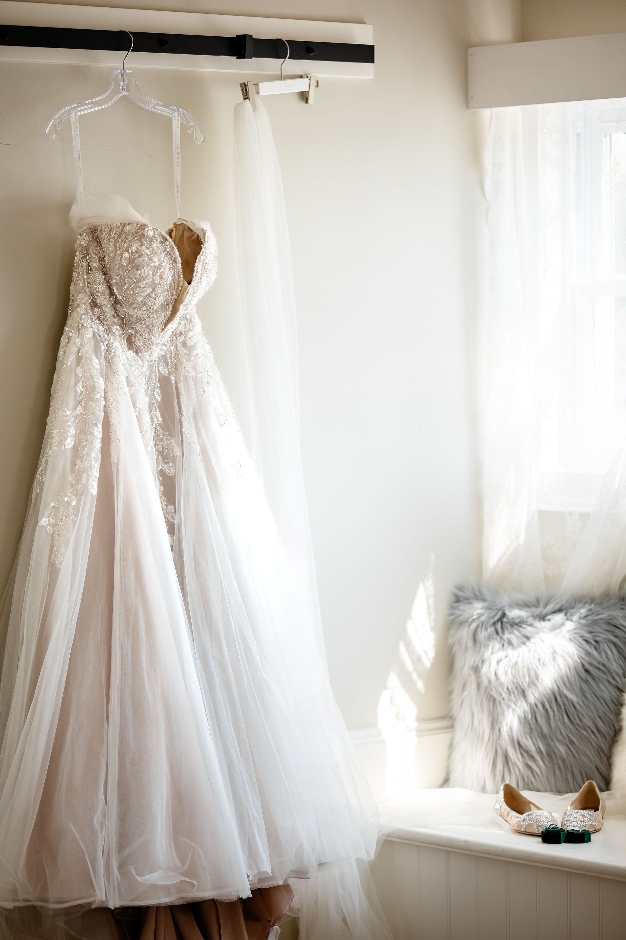 photo of a wedding dress hanging up in the getting ready space at stonefields estate