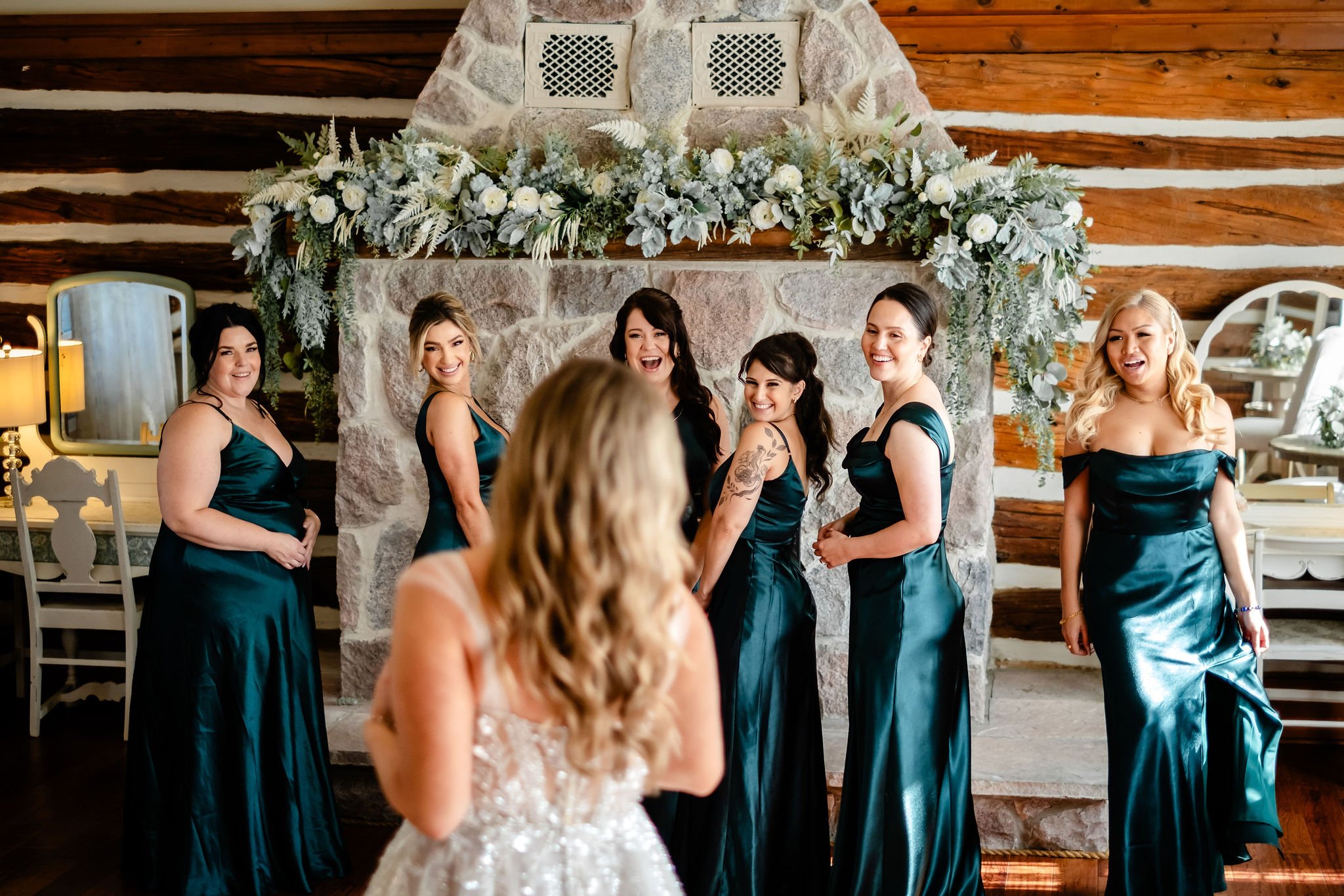 a bride revealing her wedding dress to her bridesmaids at stonefields