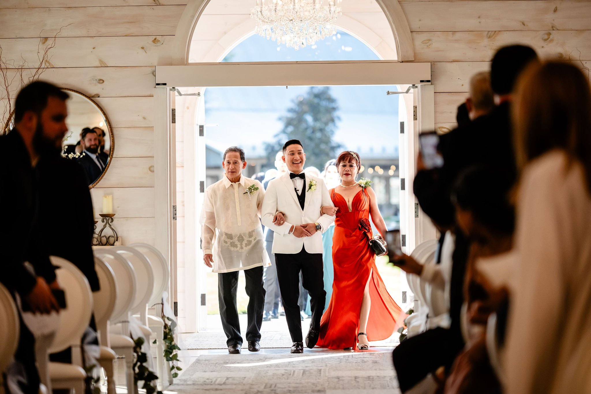 A groom walking down the aisle at his indoor wedding at stonefields estate