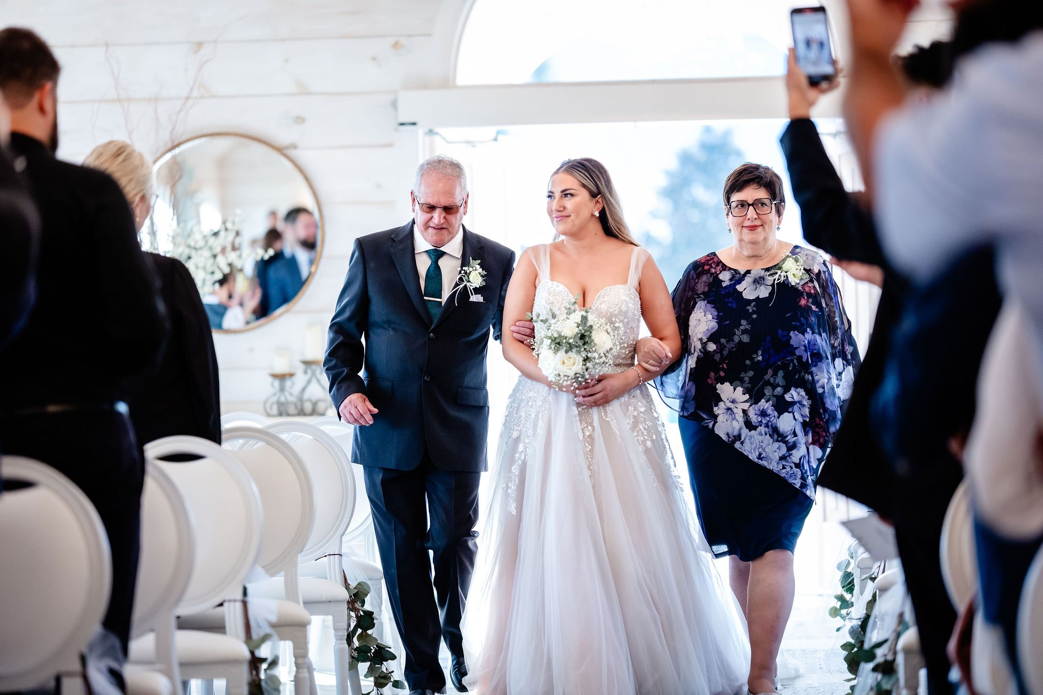 a bride walking down the aisle at an indoor wedding at stonefields estate