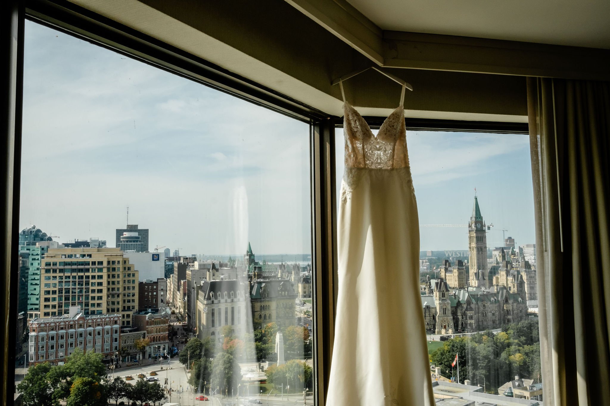 a wedding dress hanging in a window at the Westin hotel