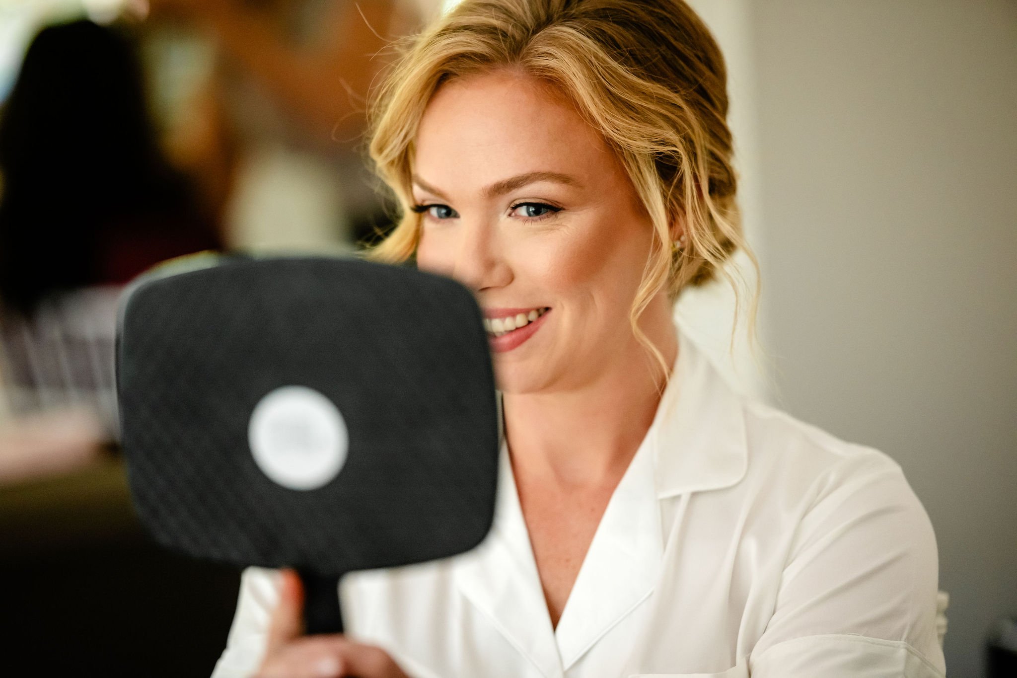 photograph of a bride seeing her makeup in a mirror