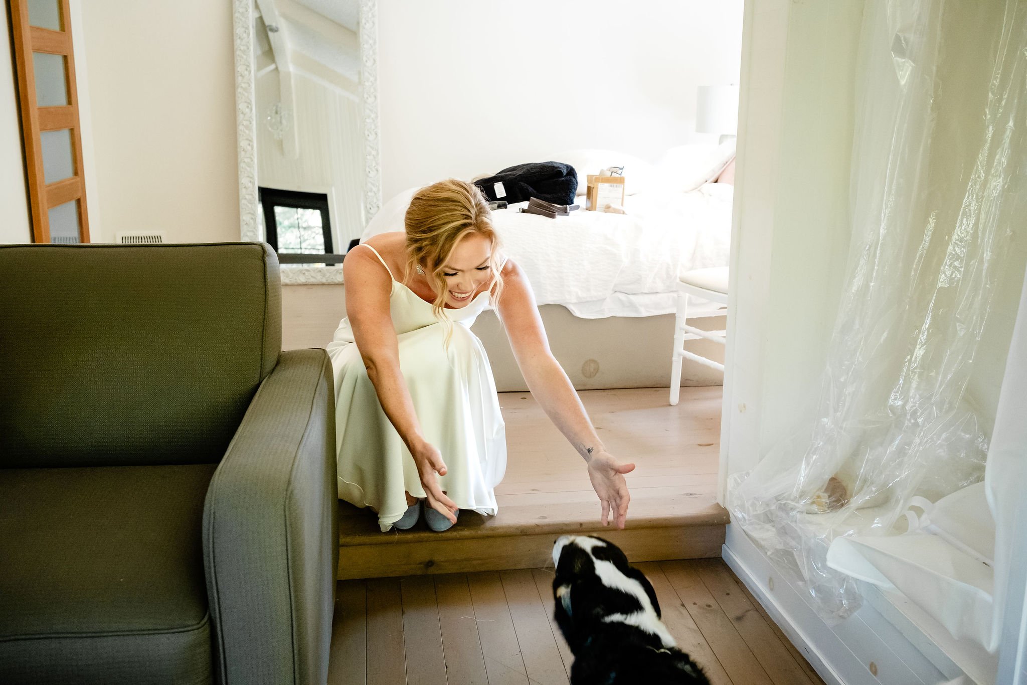 photograph of a bride about to hug her dog