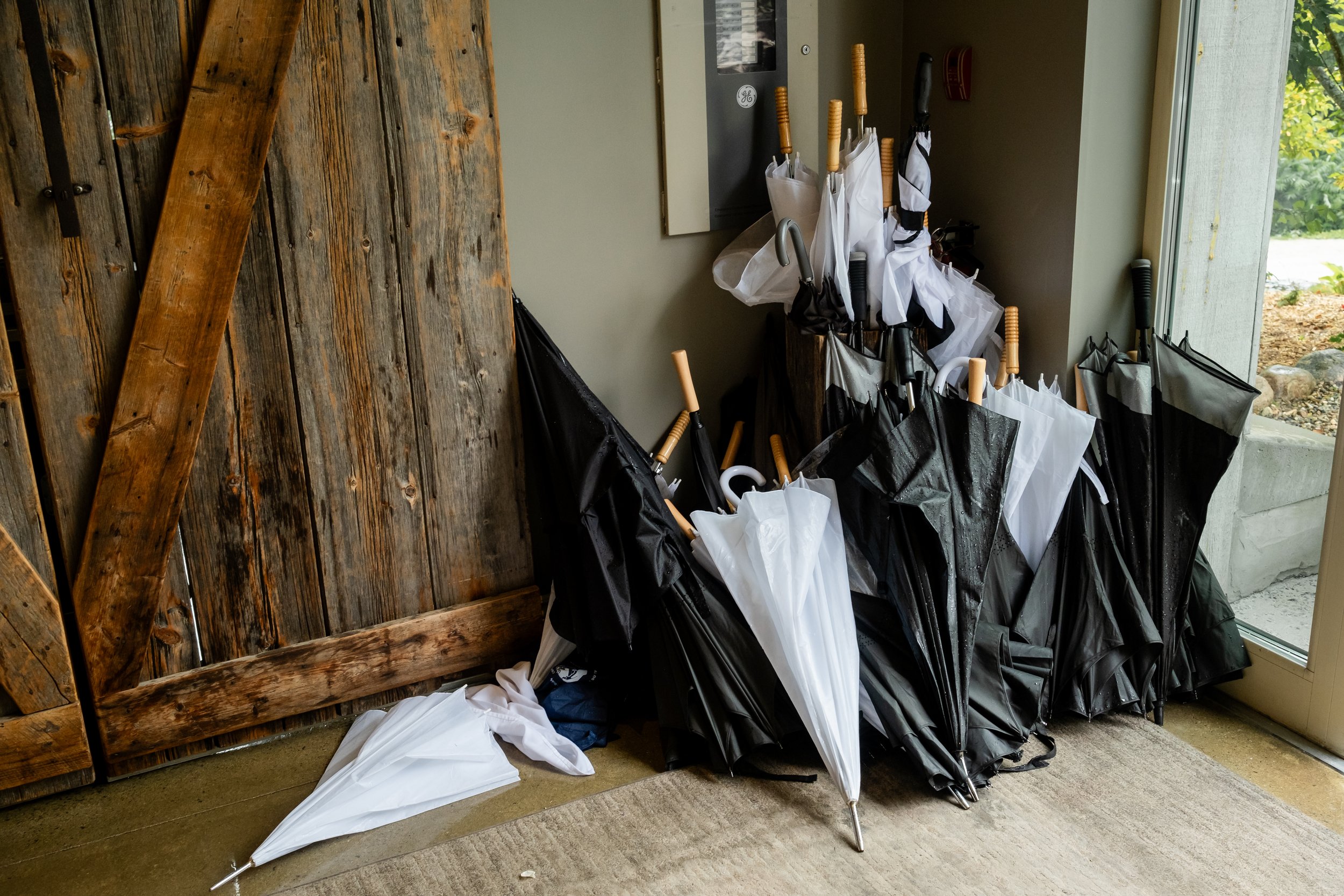 a big stack of wet umbrellas at a wedding