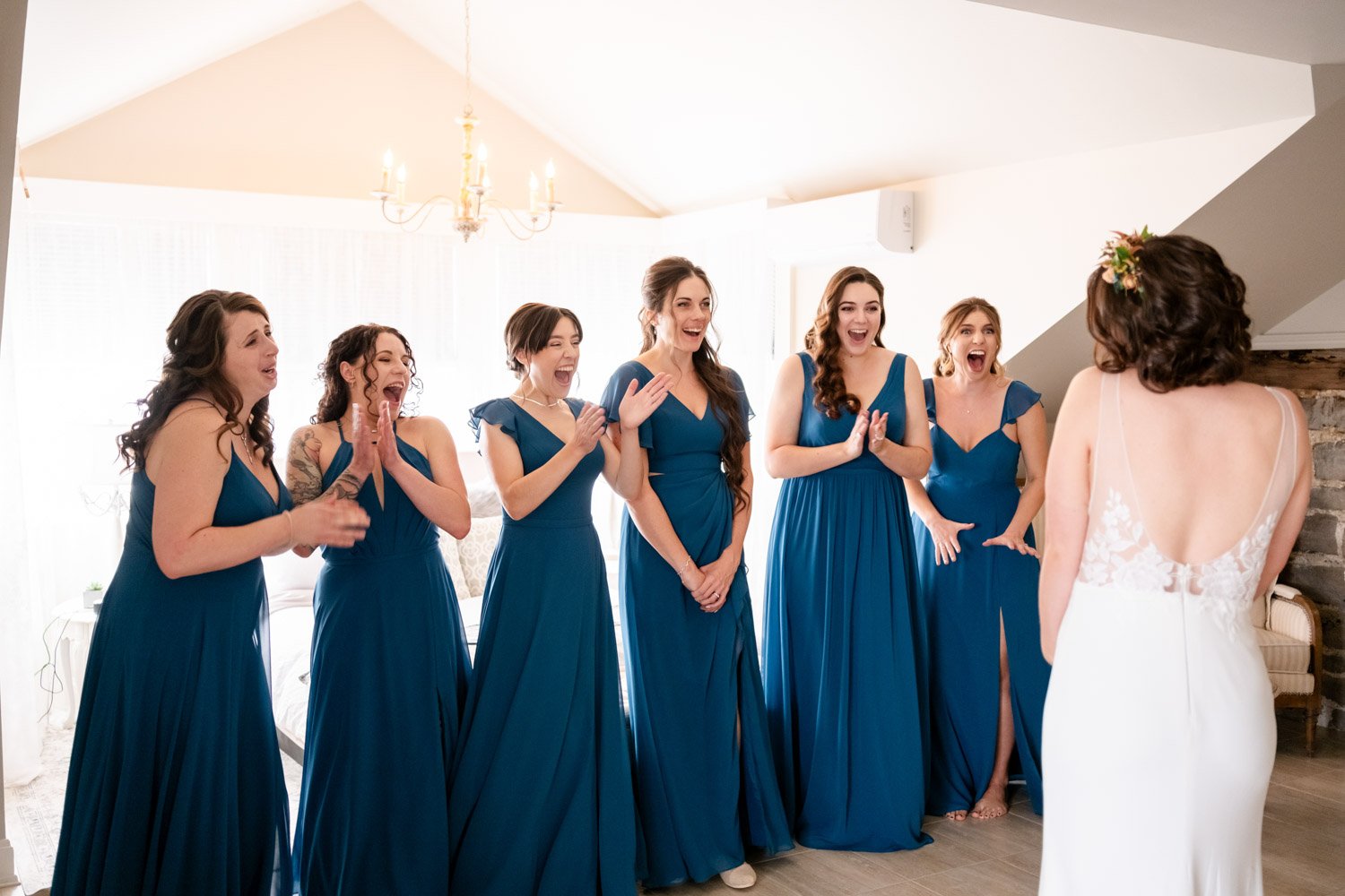 photo of bridesmaids reacting to seeing the bride in her wedding dress for the first time.