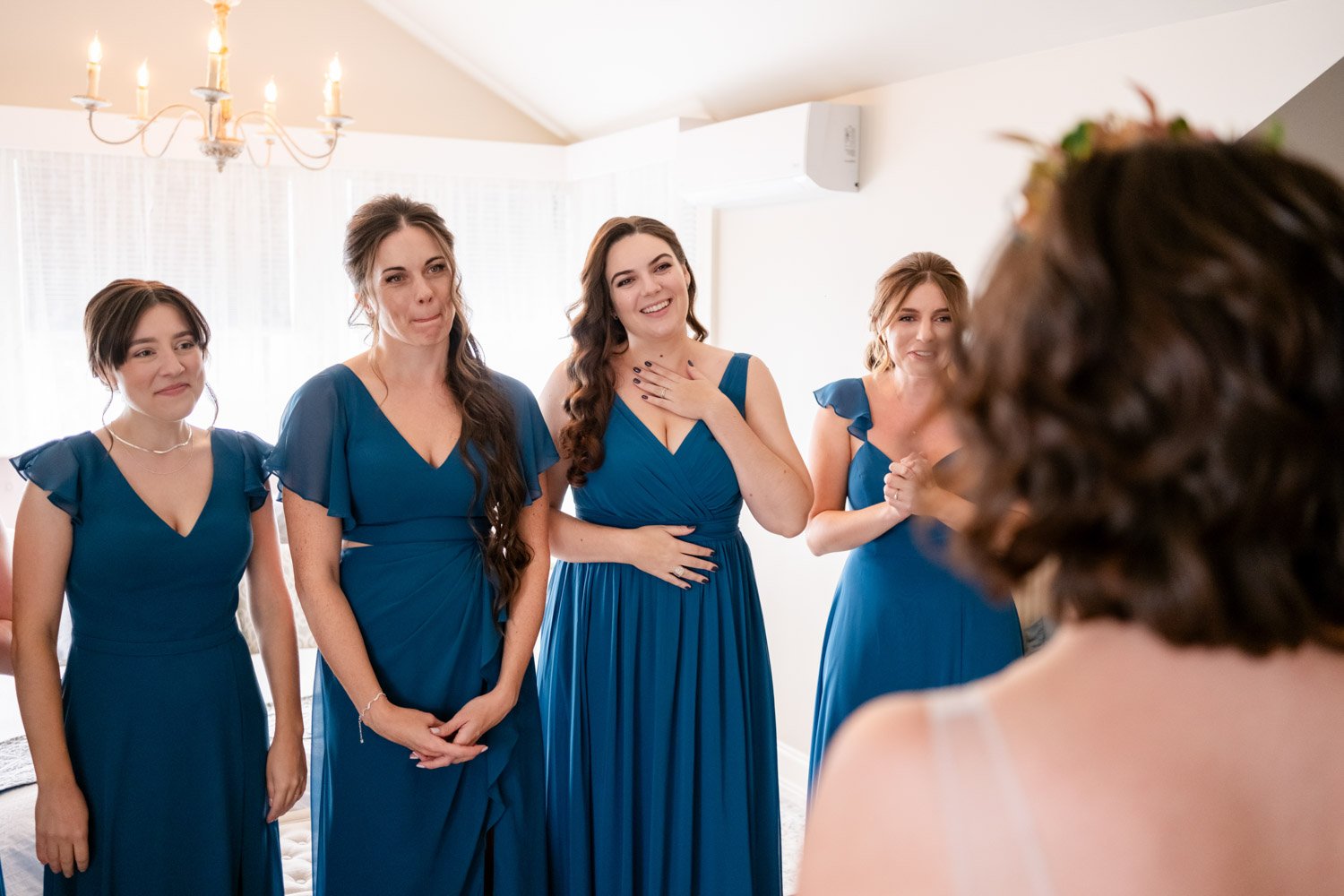 photo of bridesmaids reacting to seeing the bride in her wedding dress for the first time.