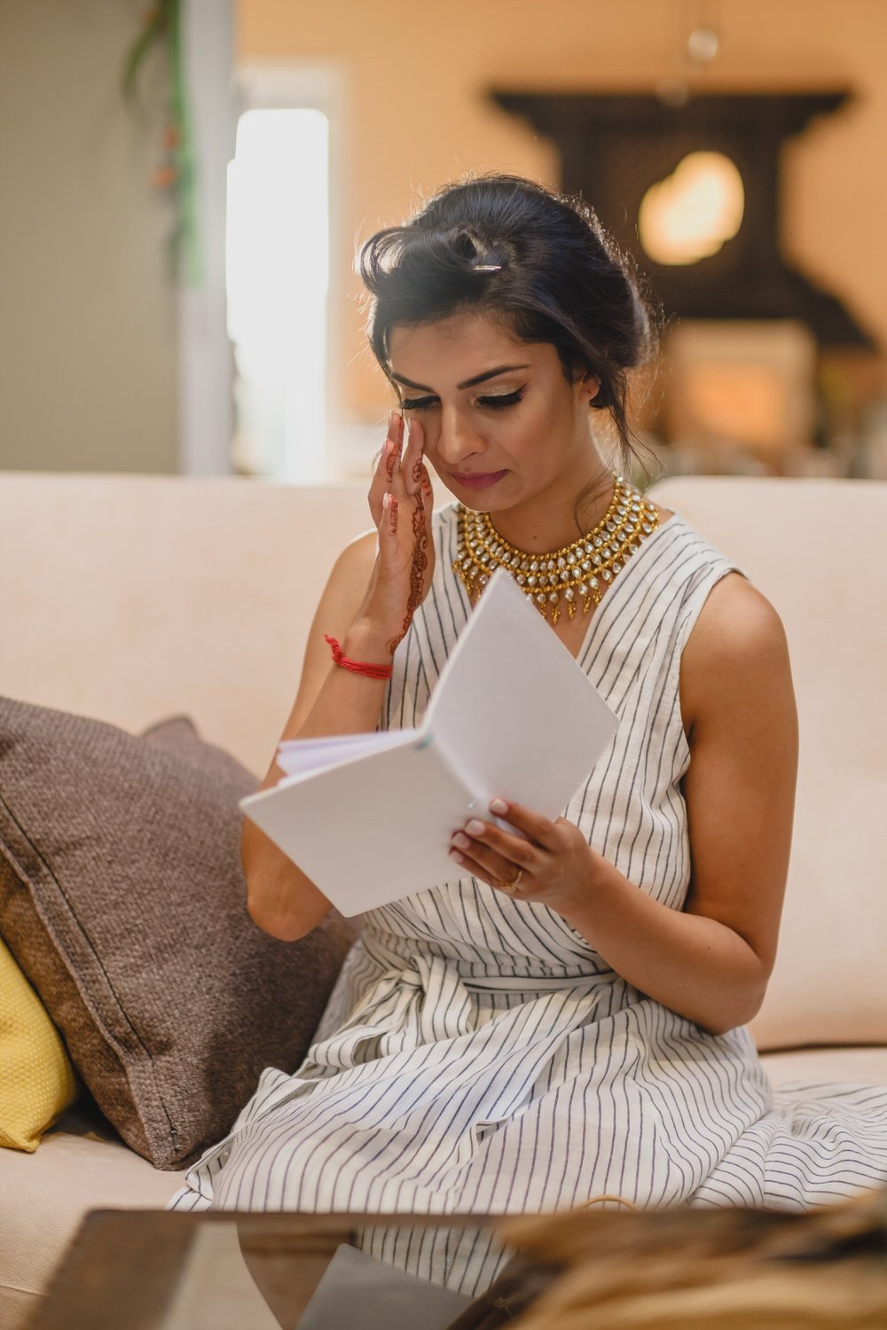 photo of a bride crying as she reads a card from her groom