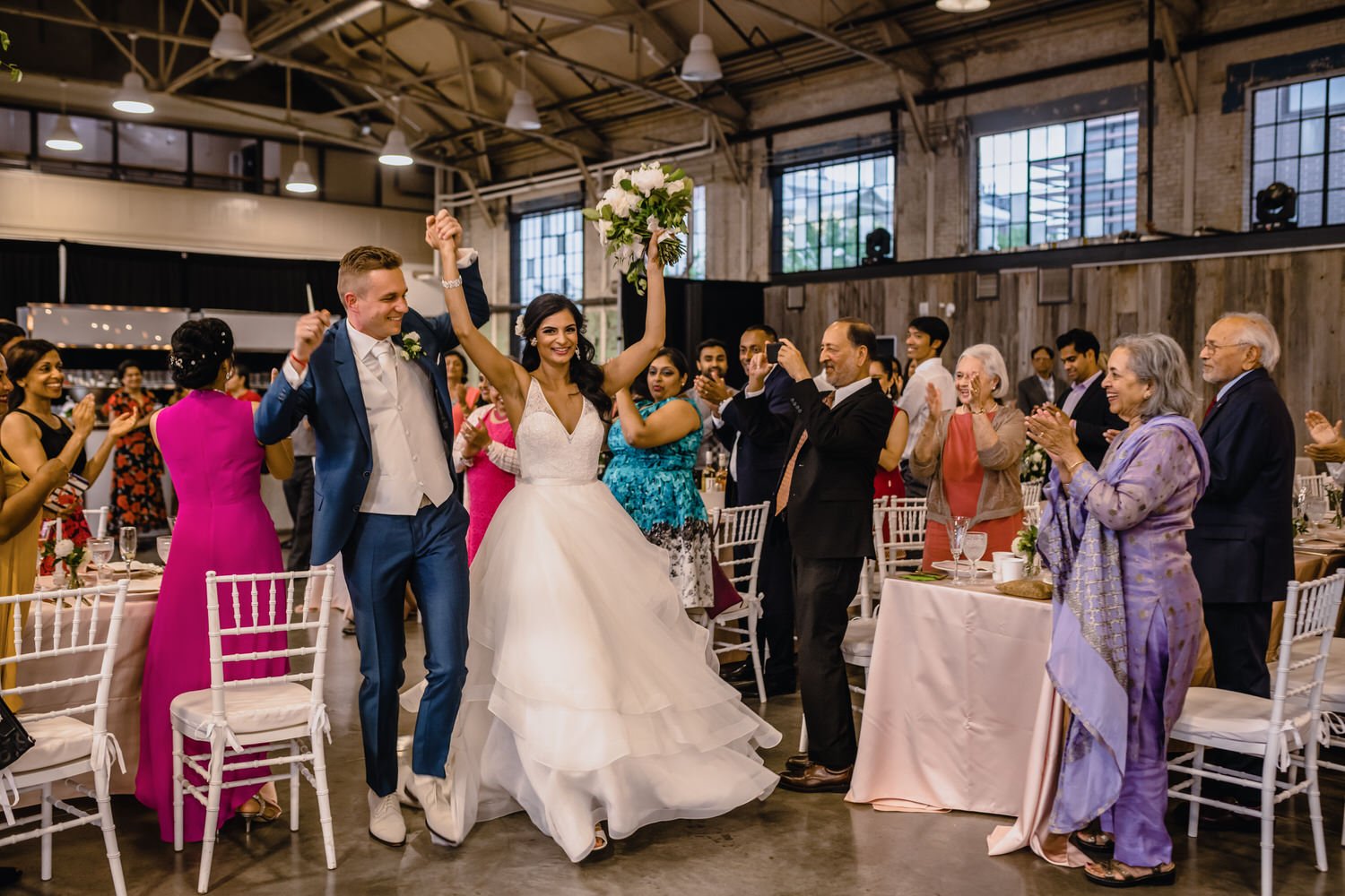 grand entrance of the bride and groom at a horticulture building wedding