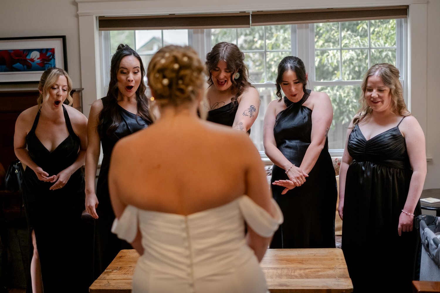 a bride doing a wedding dress reveal with her bridesmaids