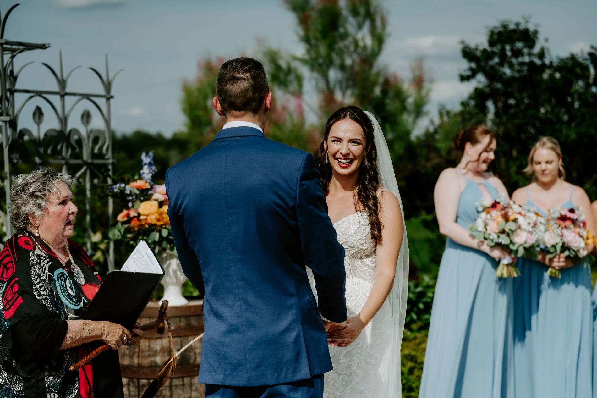 Holly beaming at Petar as the officiant reads during their outdoor ceremony at Evermore