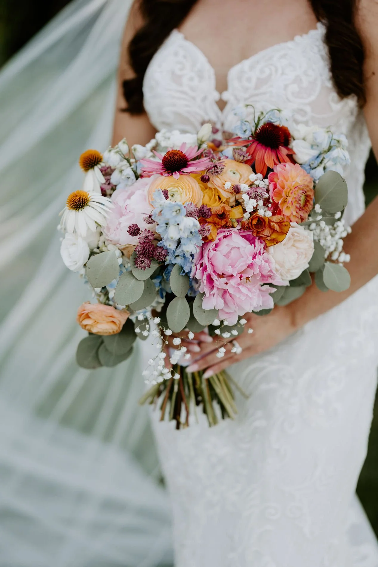 Close-up of Holly's bouquet of pink peonies, peach ranunculus, dahlias, coneflowers and eucalyptus