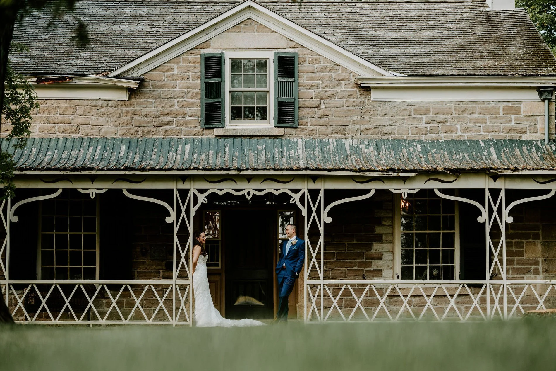 Holly and Petar on the veranda of the historic stone house at Evermore in Ottawa