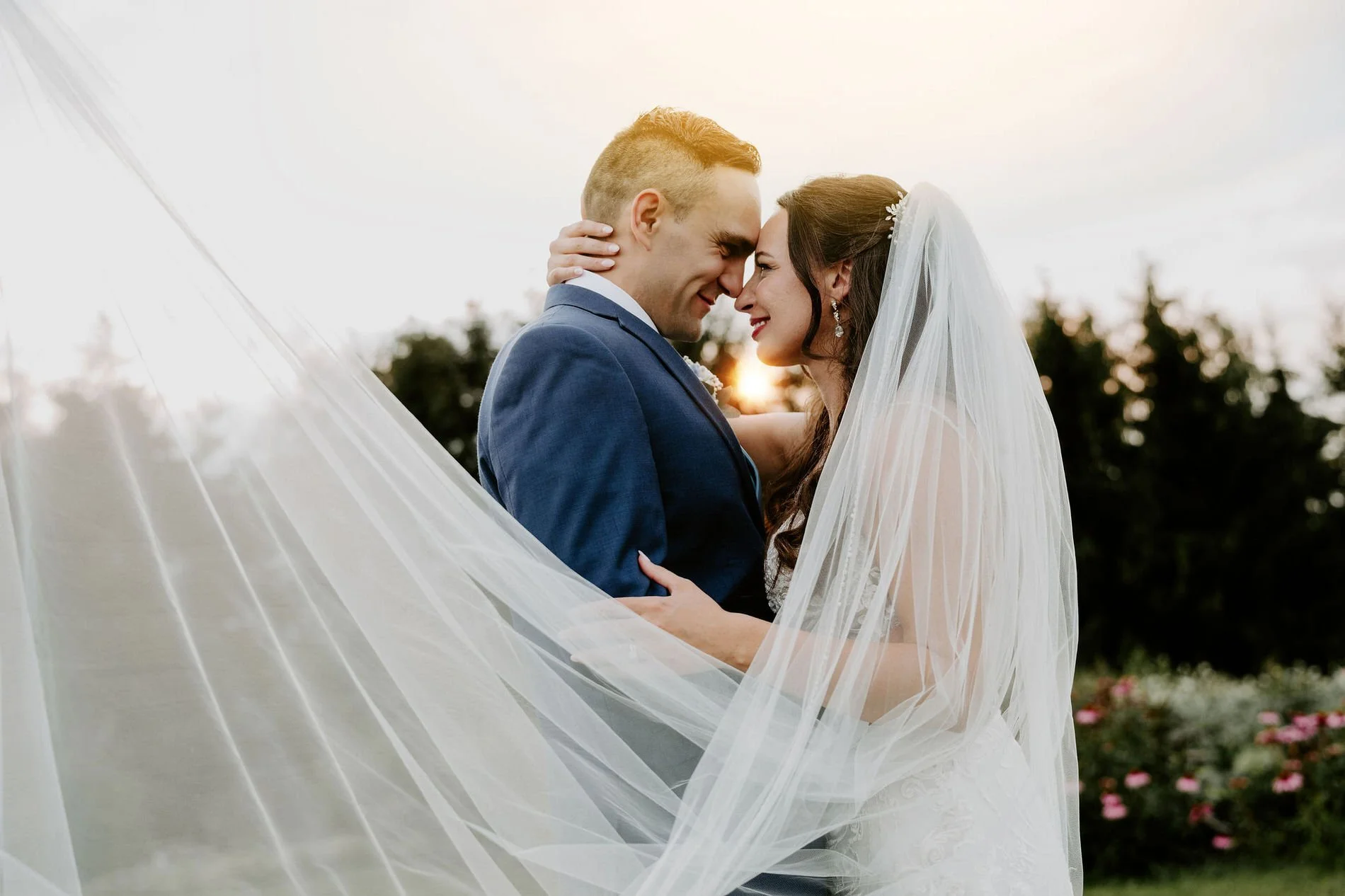 Holly and Petar embracing nose to nose at sunset, her veil sweeping across the frame