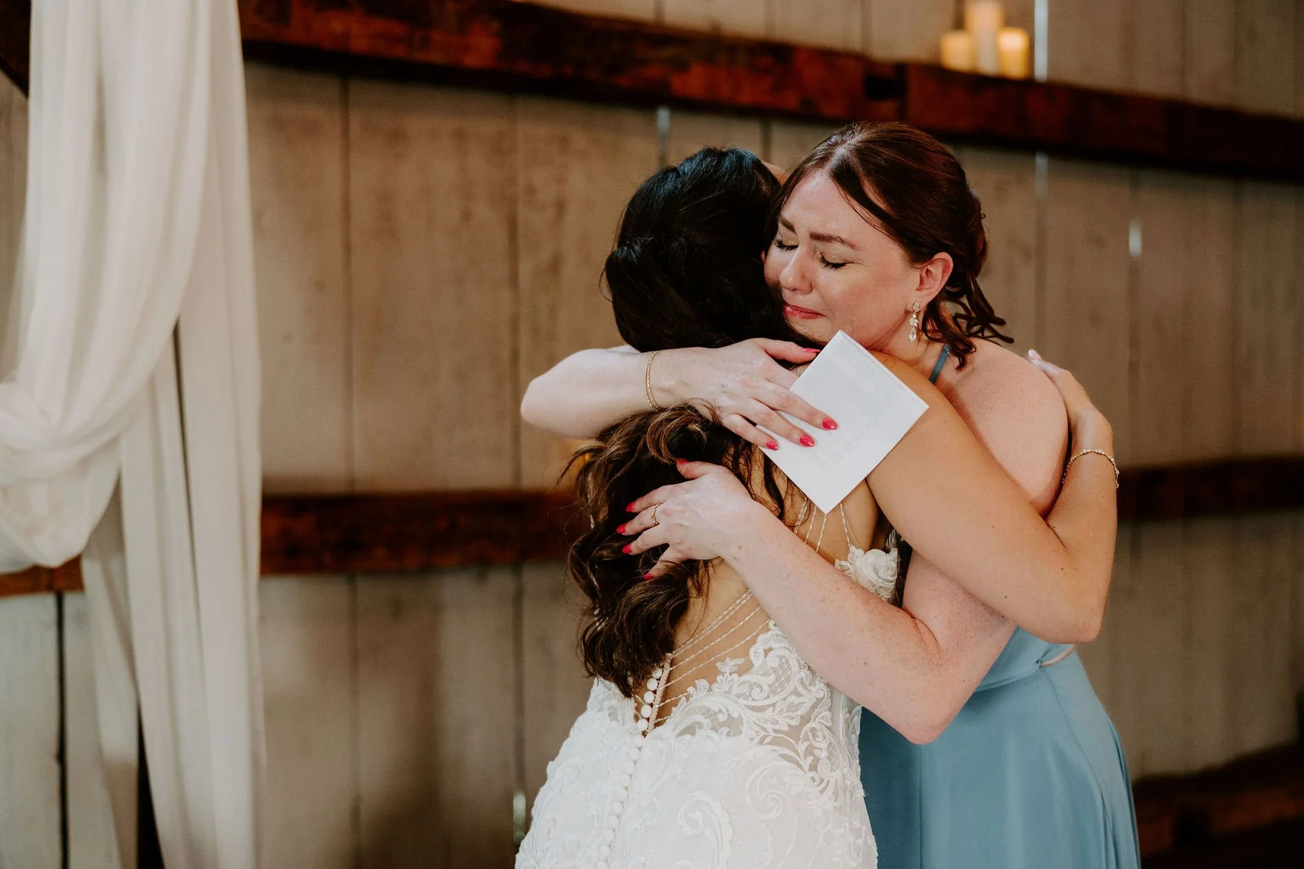 Holly hugging a tearful bridesmaid who is holding her speech card