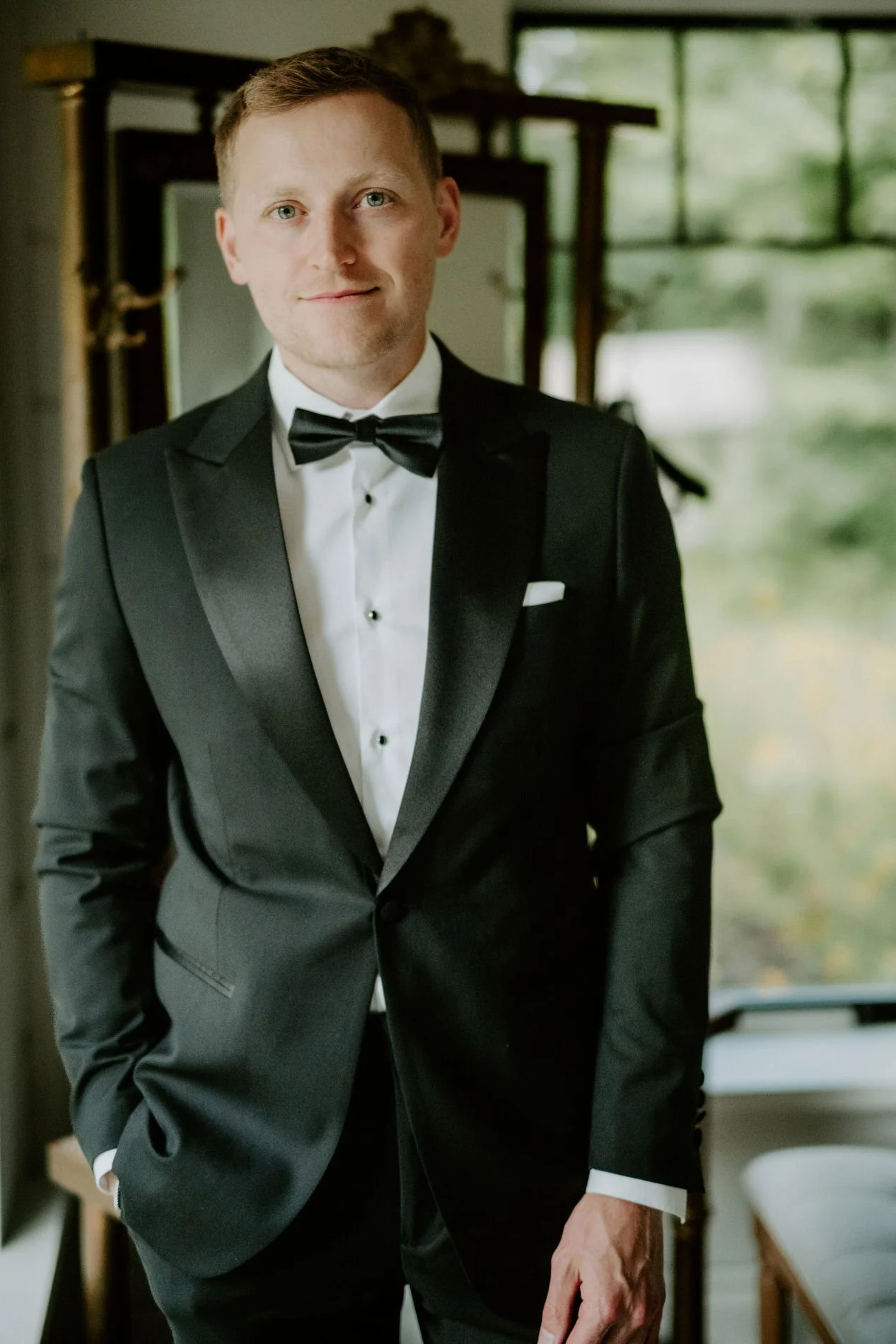 Portrait of the groom, Will, in a black tuxedo and bow tie on the morning of his wedding