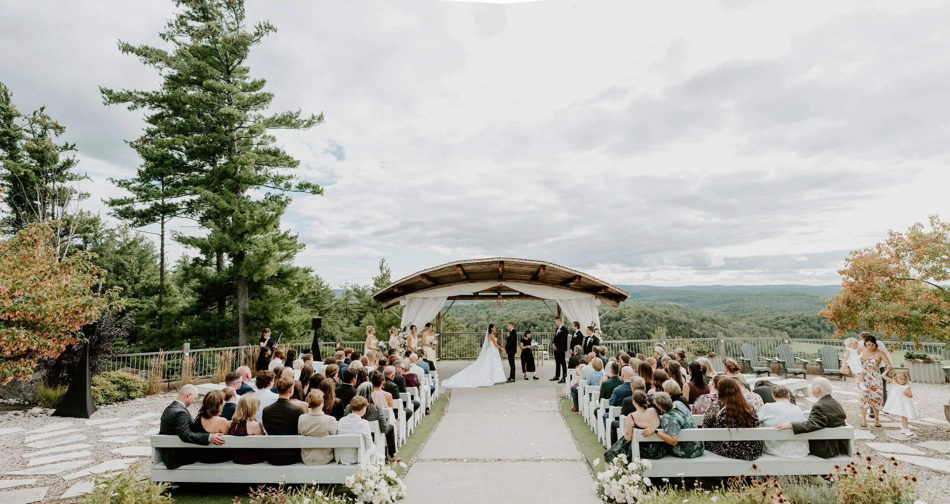 Wide view of Kylie and Will's outdoor ceremony at Le Belvedere in Wakefield, with guests facing the hilltop pavilion