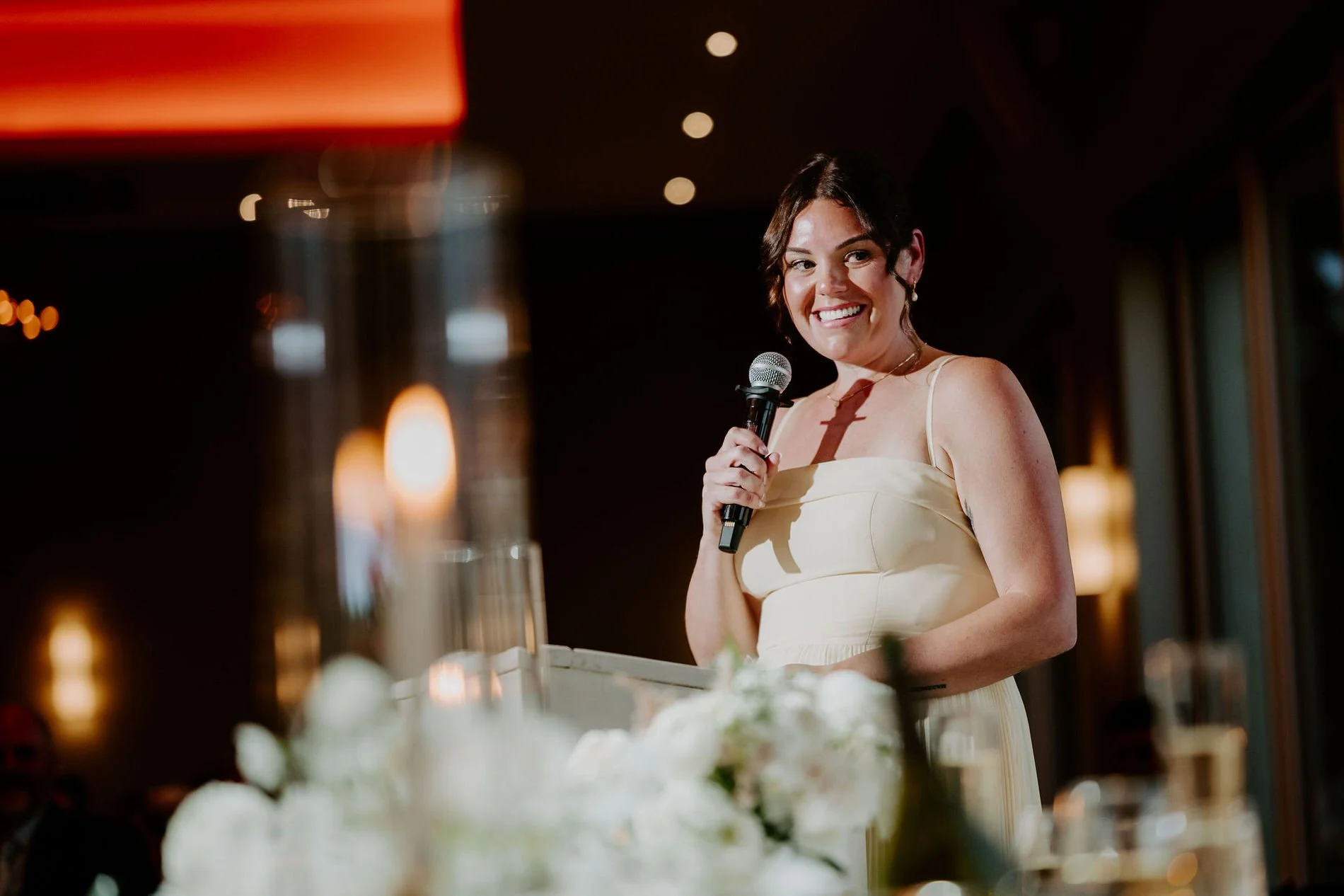 A bridesmaid smiling as she gives a speech at Kylie and Will's reception